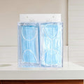2-compartment acrylic dispenser filled with face masks on a bathroom countertop