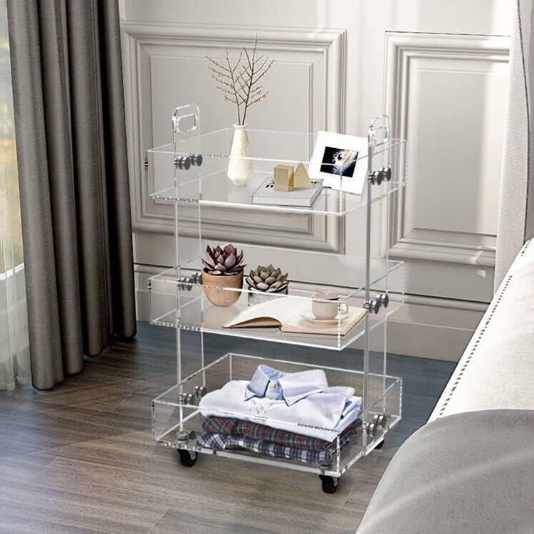 3-tier clear acrylic rolling cart used as a bedroom organizer for clothes, decor, and books
