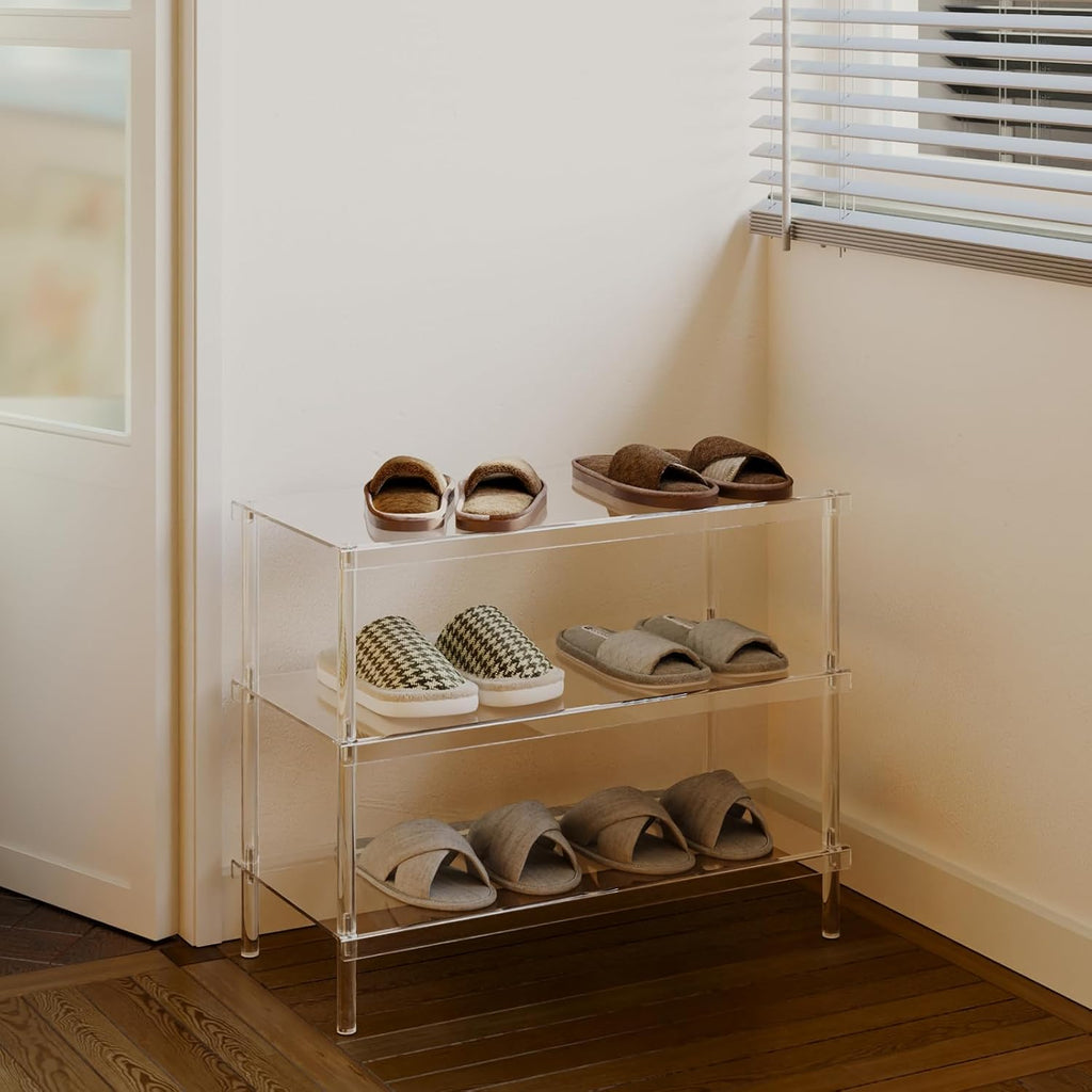 3-tier clear acrylic shoe rack in an entryway corner, storing slippers and casual shoes