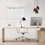 Clear acrylic wall calendar installed in a contemporary office workspace