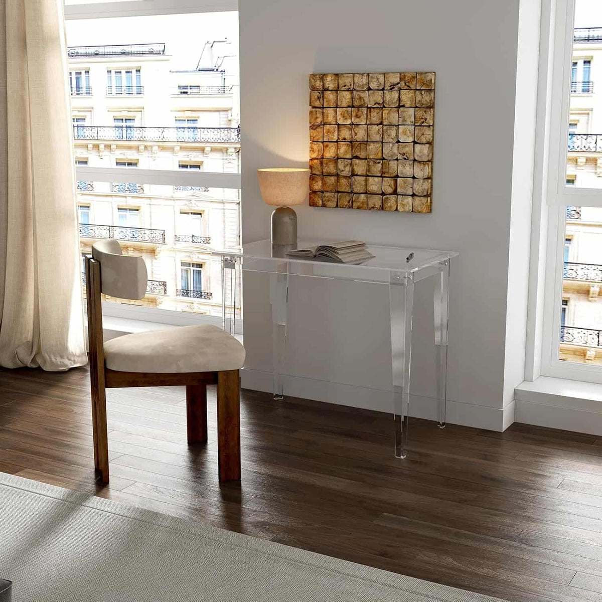 Transparent acrylic desk used as a workspace in a bedroom with a window view