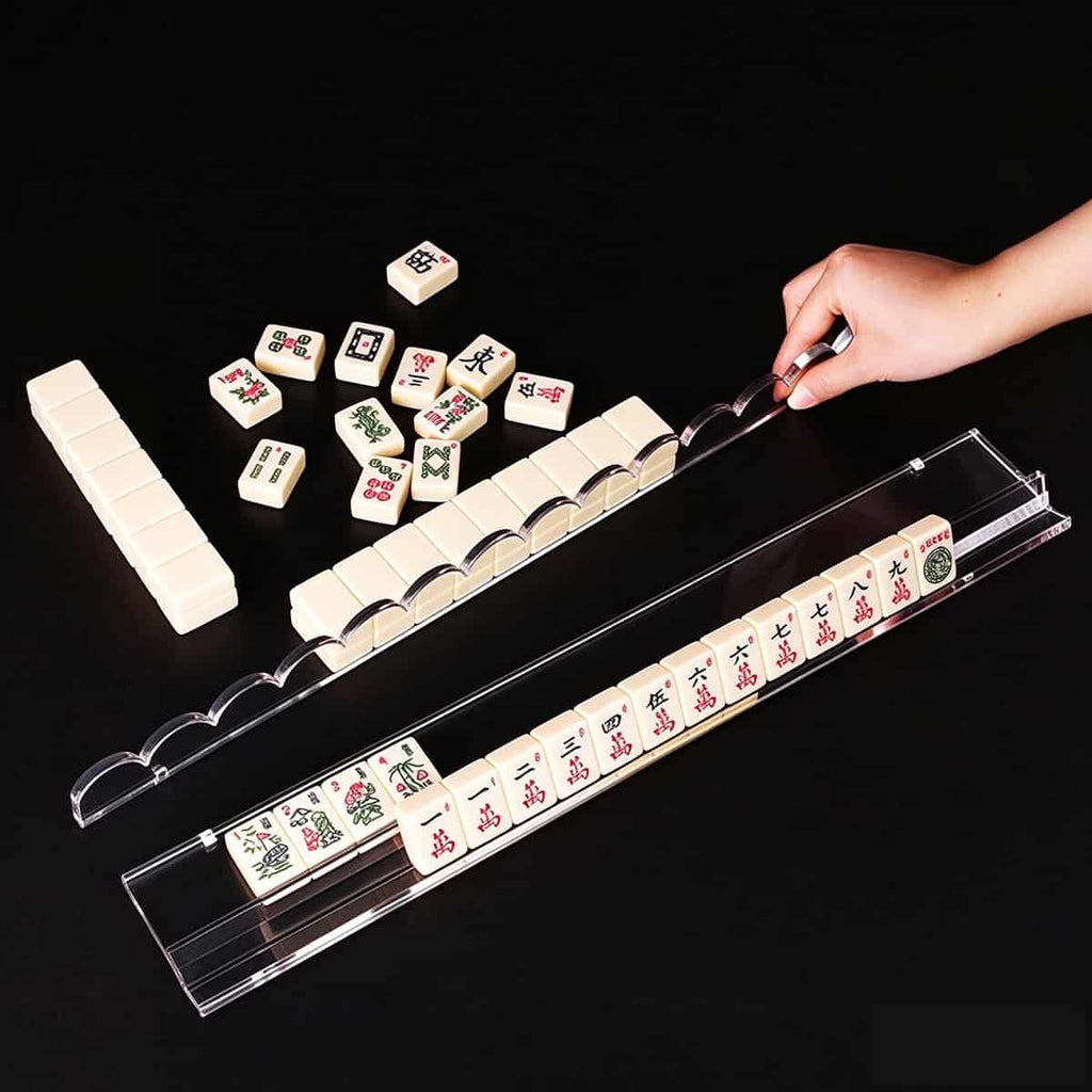 Hand demo using magnetic acrylic mahjong pusher on clear scalloped mahjong rack, mahjong tiles for demonstration only, black background