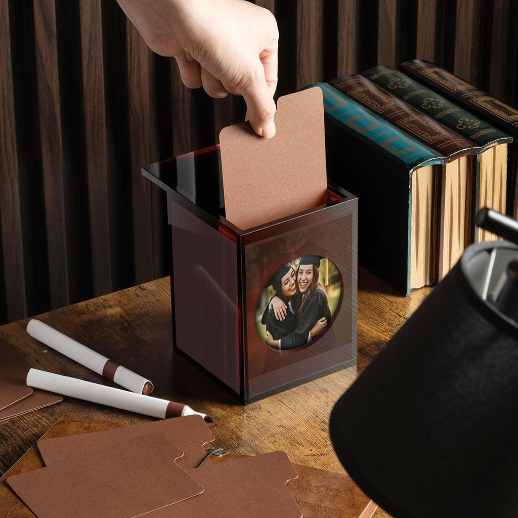 Hand pulling a photo card from the acrylic box, demonstrating easy access to stored photos/cards