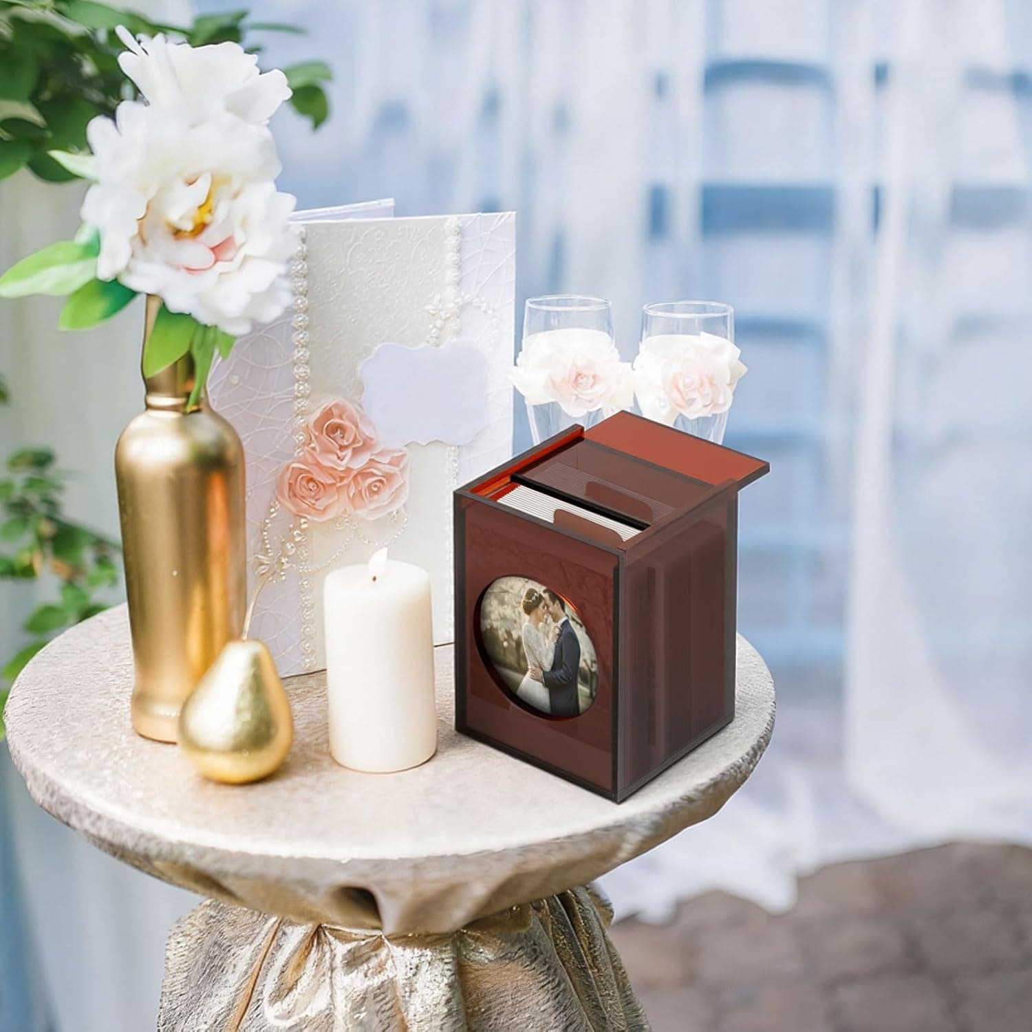 Acrylic photo box used as wedding decor on a round table, paired with flowers and candles for a elegant event setup
