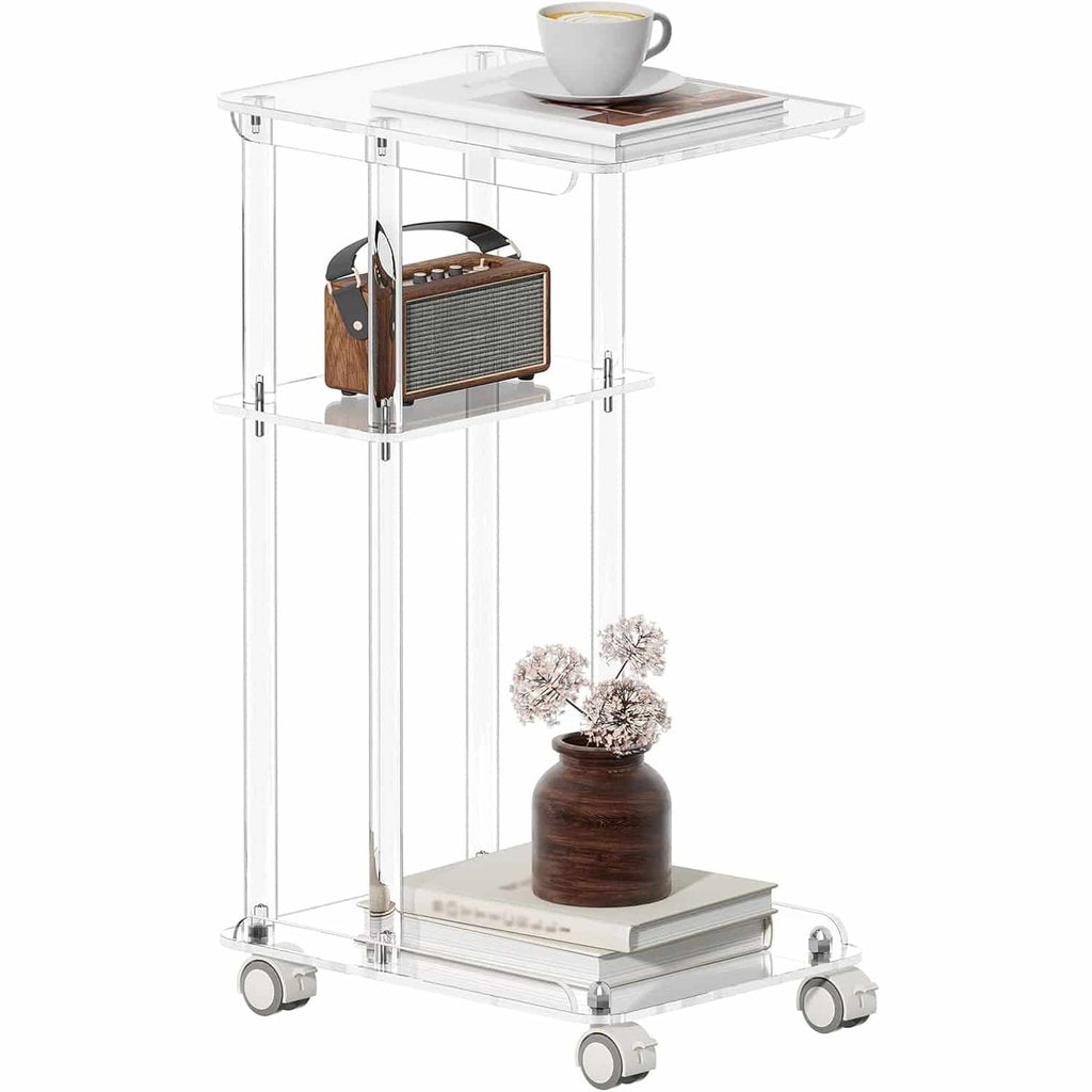 A 3-tier clear acrylic rolling side table with a coffee cup, radio, and potted plant, showcasing its minimalist design