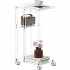 A 3-tier clear acrylic rolling side table with a coffee cup, radio, and potted plant, showcasing its minimalist design