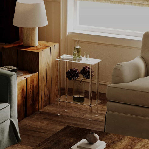 2-tier acrylic side table placed next to a beige armchair in a cozy living room setting