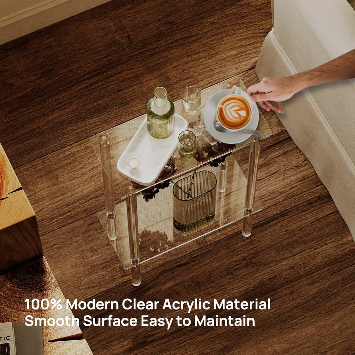 2-tier acrylic side table used as a drink table by a sofa, holding coffee and refreshments