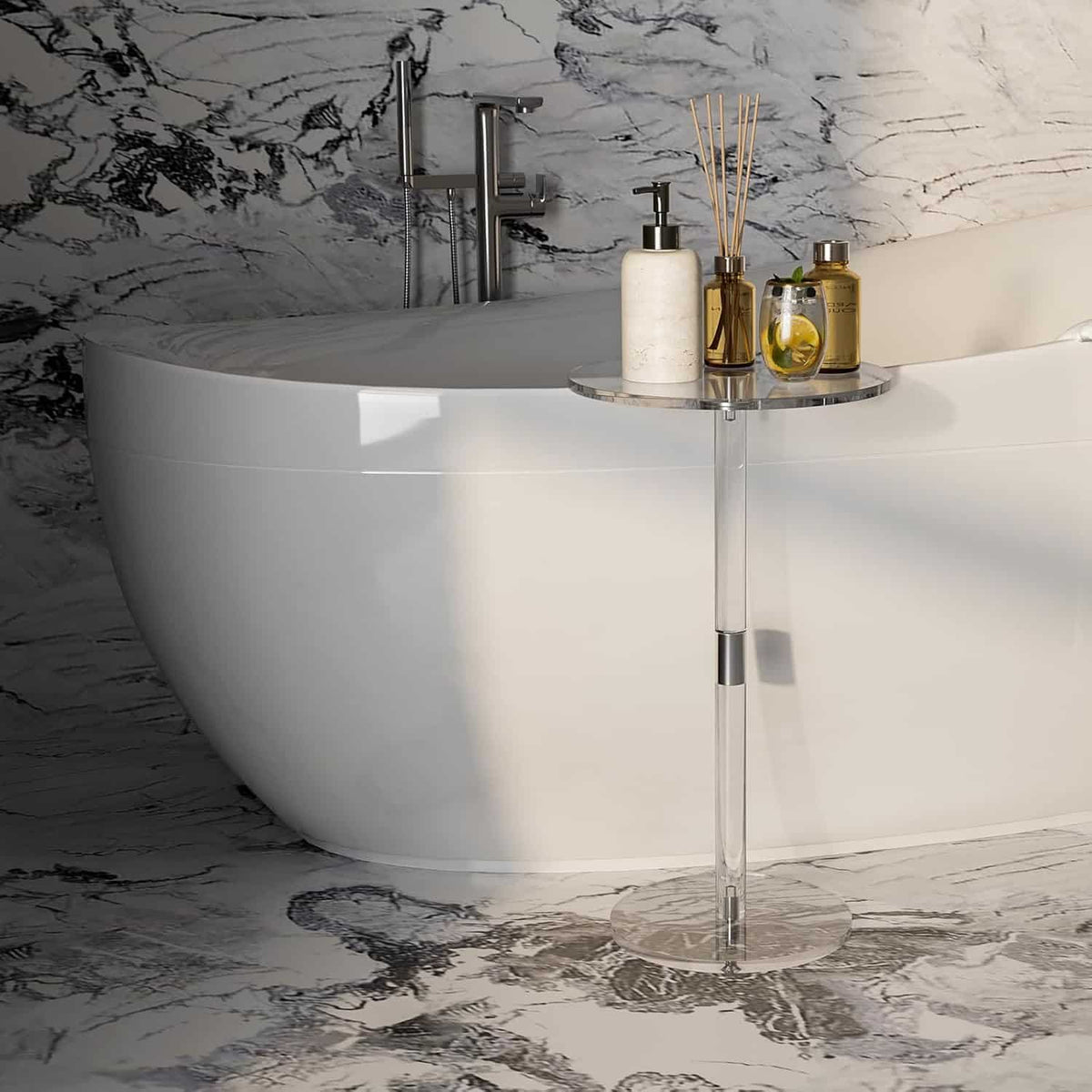 A clear acrylic side table next to a freestanding bathtub, holding bathroom accessories like soap dispenser and reed diffuser