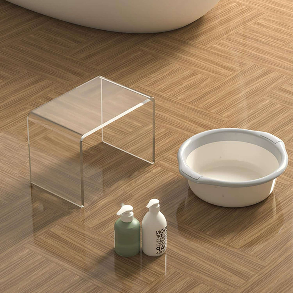Transparent acrylic step stool with lotion bottles and a basin in a modern bathroom
