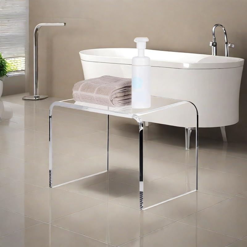 Transparent acrylic bench with towels and soap dispenser placed by a modern freestanding tub