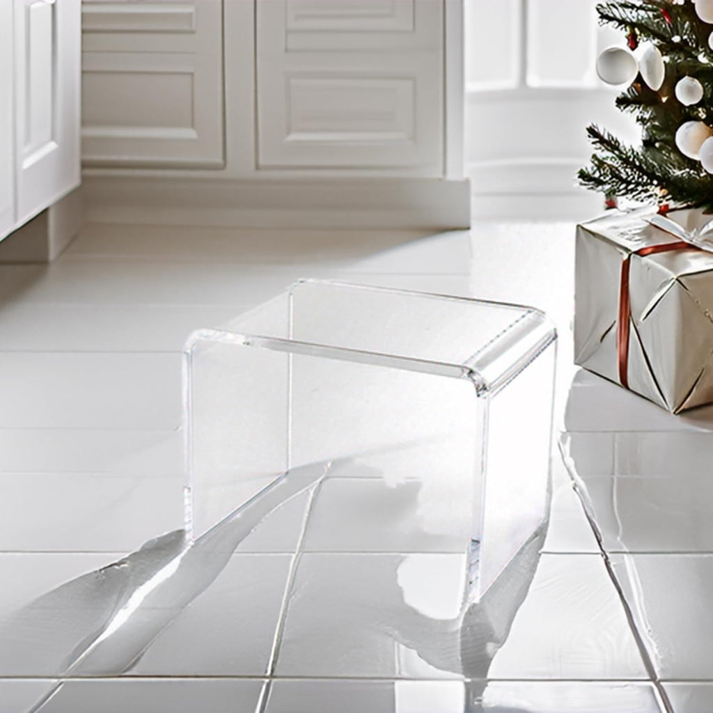 Clear acrylic step stool in a festive Christmas setting with a tree and gift boxes