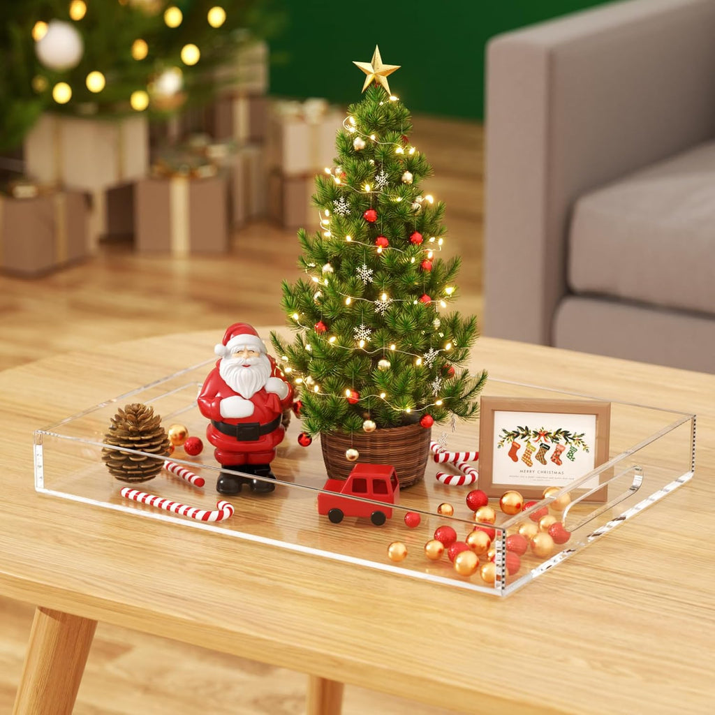 Clear acrylic tray used as a Christmas decor centerpiece with a mini tree and ornaments