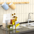Acrylic tray organizing kitchen essentials like oil, vinegar, and sugar cubes on a countertop