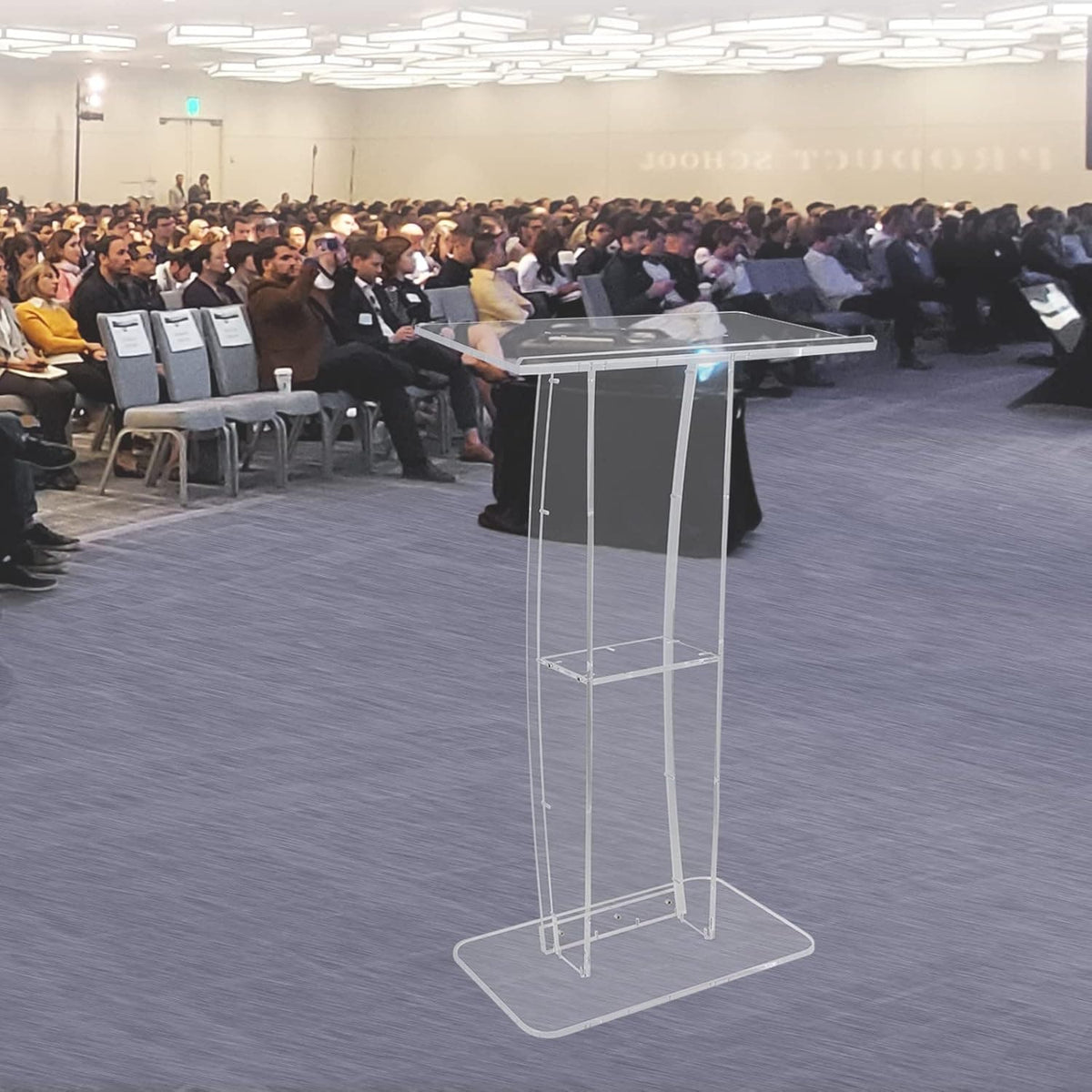 Transparent acrylic podium standing in front of a large audience at a conference, providing a modern and elegant speaking platform