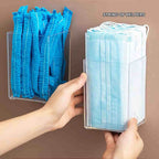 Hand holding clear acrylic wall storage container for disposable masks and hairnets