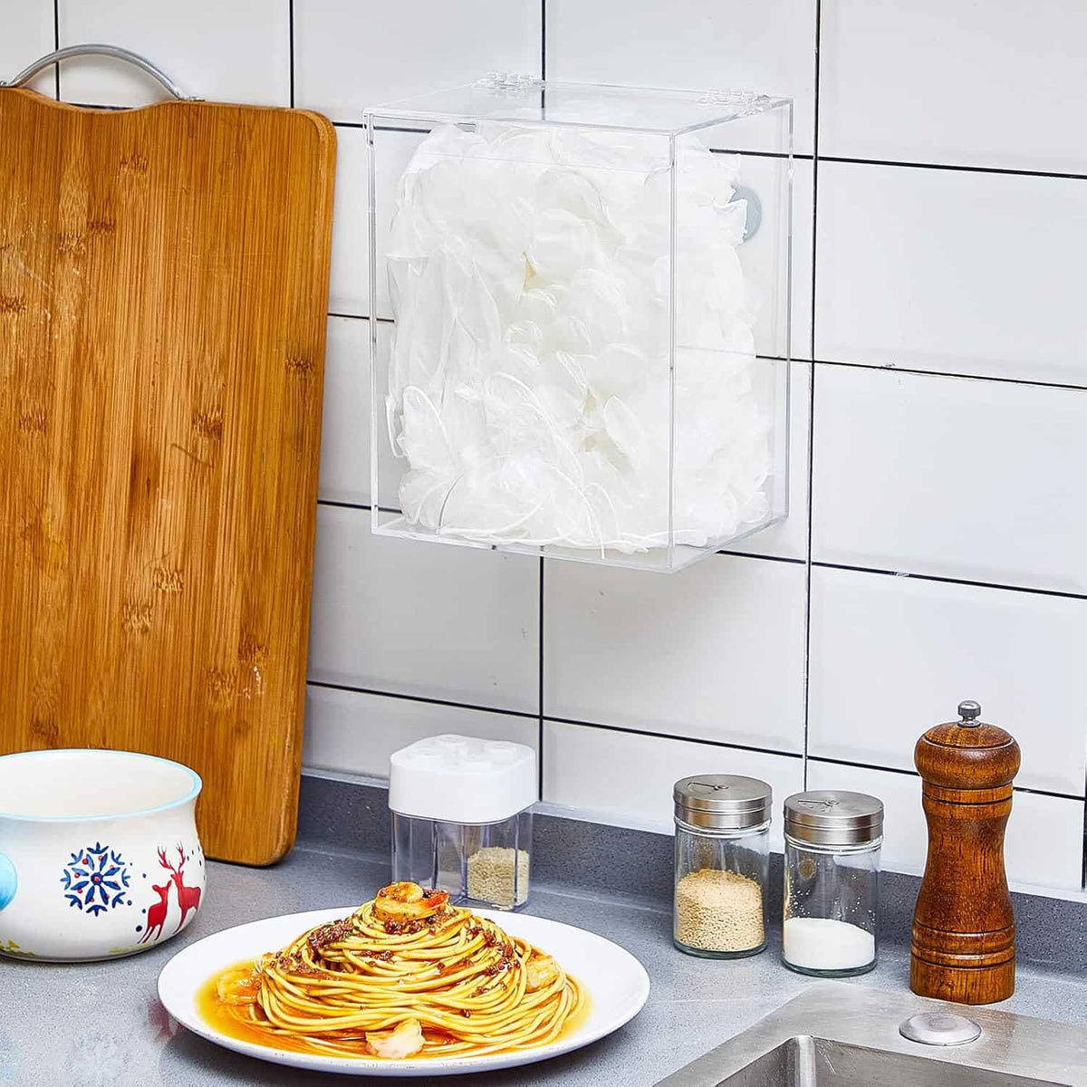 Wall-mounted clear acrylic dispenser holding hairnets in a kitchen setting, keeping food prep areas organized