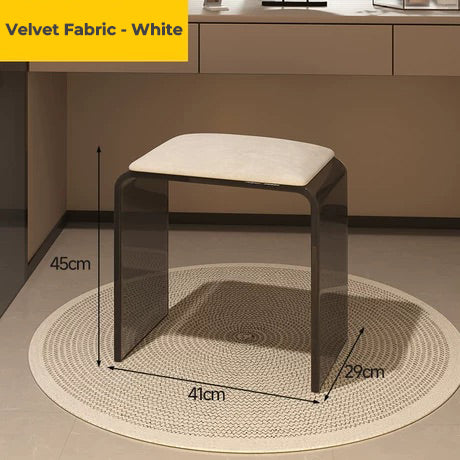 Smoke black acrylic vanity stool with white velvet fabric cushion, styled on a woven rug