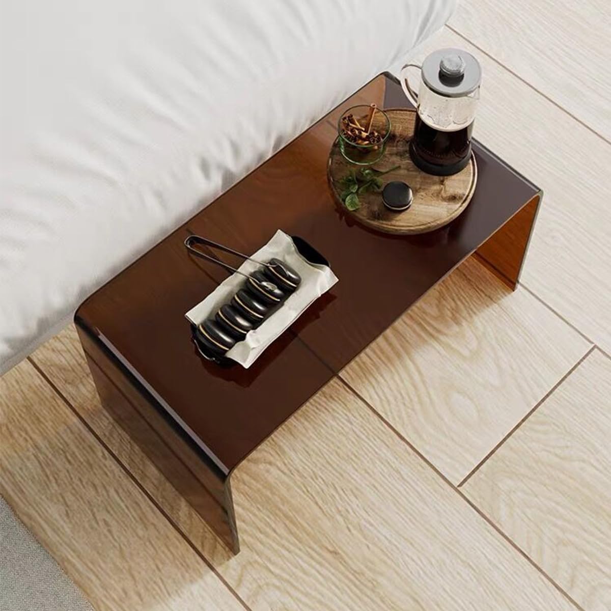 Smoky brown acrylic coffee table with a tea setup, showcasing its sleek, translucent design in a bedroom setting