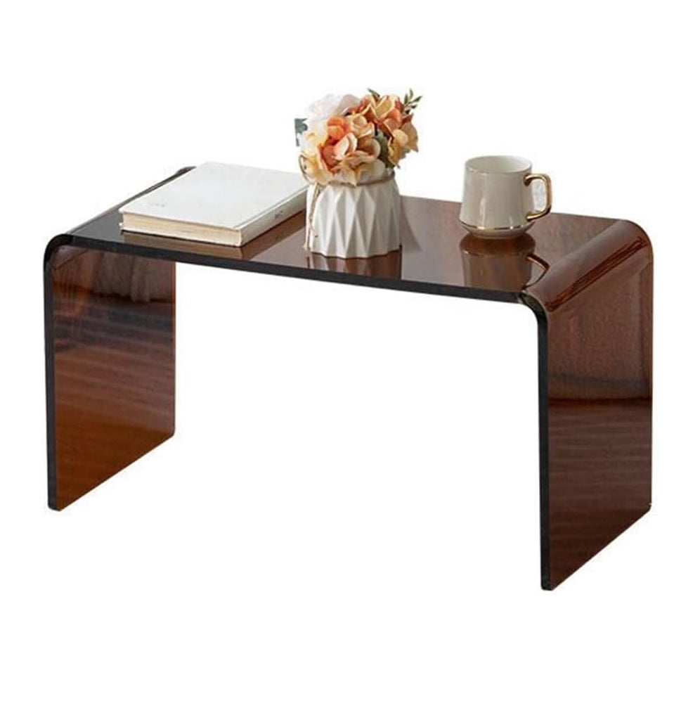 Smoky brown acrylic side table styled with a vase of flowers, book, and coffee cup for a modern living room look