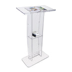 Clear acrylic podium with a slanted desktop, built-in storage shelf holding books, and a wide stable base, ideal for speeches and presentations