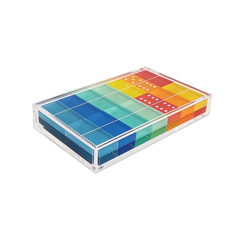 Clear acrylic storage box filled with rainbow colored acrylic domino tiles, white background