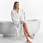 Woman in a white bathrobe relaxing on a transparent acrylic shower bench by a clawfoot tub